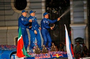 O piloto Andrey Karginov comemora sua vitória no Rali Dakar 2014 com seus companheiros de equipe, o co-piloto Andrey Mokeev e o mecânico Igor Devyatkin (Crédito da foto: DPPI/F.le Floch)